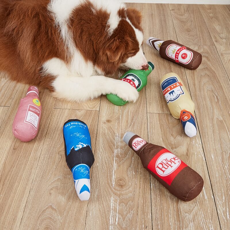 El perro chirriante lindo divertido de la felpa juega la cerveza y las bebidas mastican los juguetes